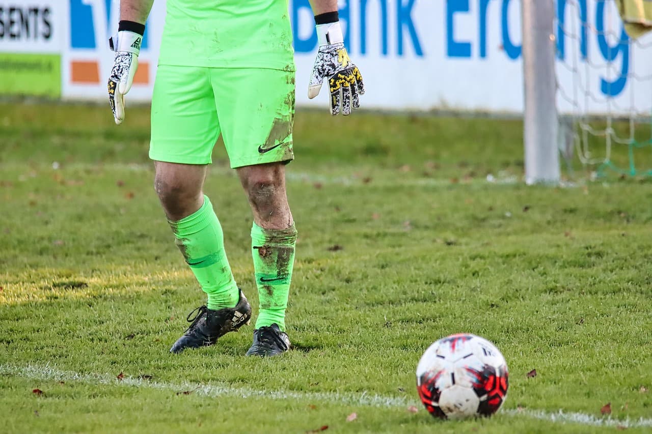 Goalkeeper standing on a grass pitch