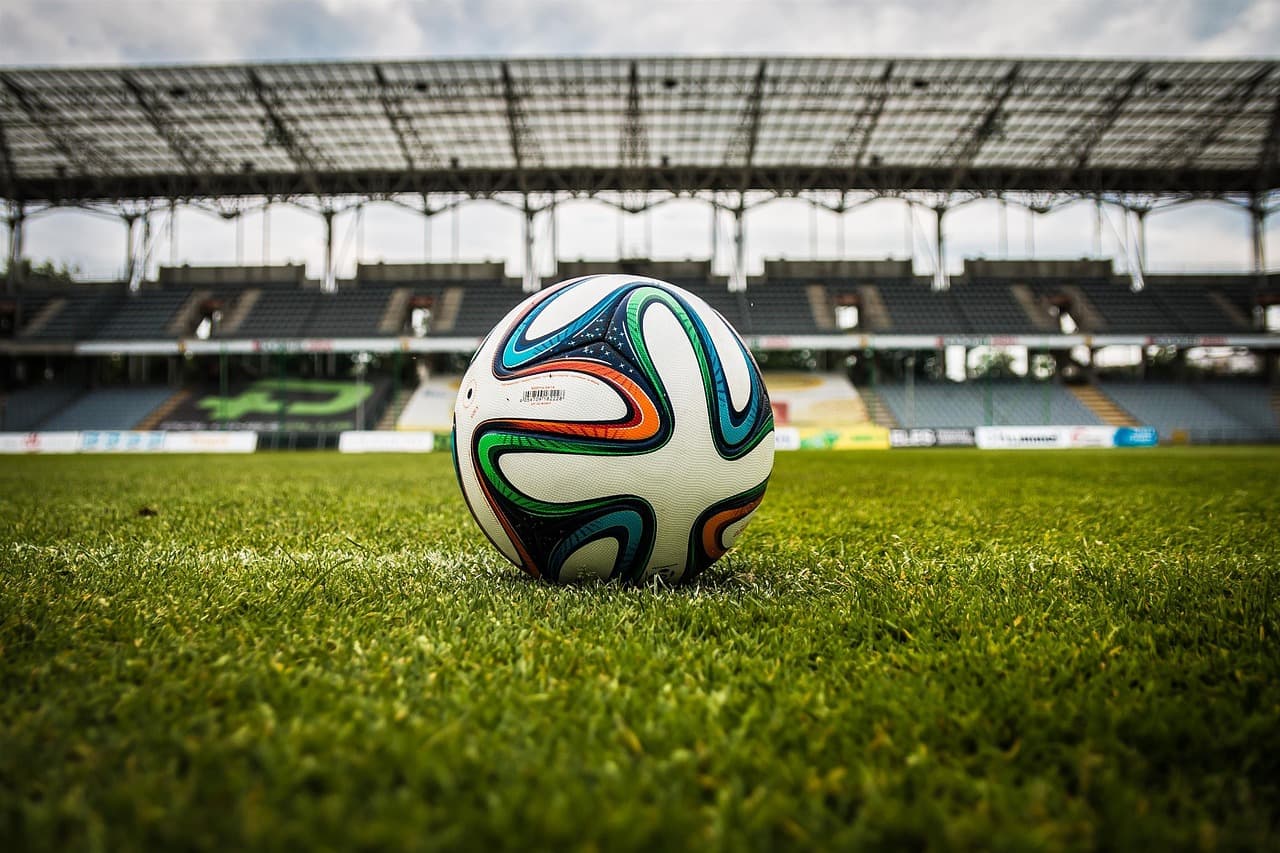 Players contesting a football on the pitch